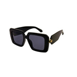 Black sunglasses with a gold accent on a white background