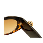 Sunglasses with a gold temple piece on a white background