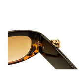 Sunglasses with a gold temple piece on a white background