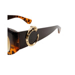 Sunglasses with tortoiseshell arms and gold horseshoe design on a white background