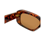 Sunglasses with tortoiseshell frame and brown lens on a white background